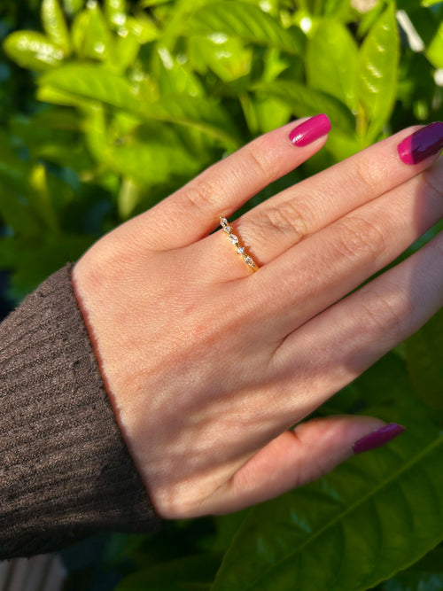 Minimalist tasarıma sahip, üzerinde tek bir parıltılı taş bulunan altın kaplama ince yüzük modeli.